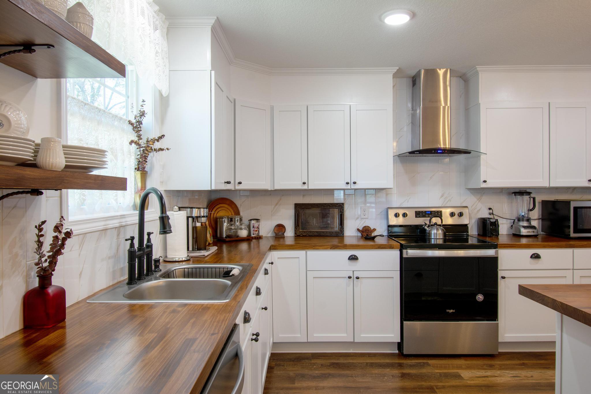 149 Main Street Rocky Ford, GA 30455 - Photo 18 of 44 a kitchen with granite countertop a sink a stove and cabinets