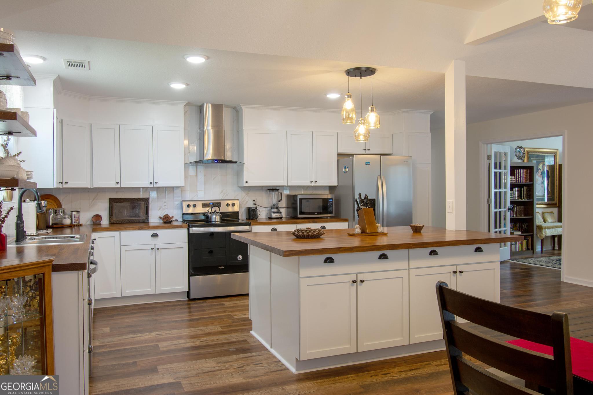 149 Main Street Rocky Ford, GA 30455 - Photo 5 of 44 a kitchen with kitchen island granite countertop a sink cabinets and stainless steel appliances