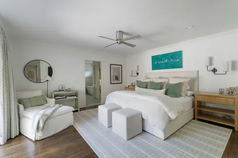 a spacious bedroom with a bed a mirror and lamp