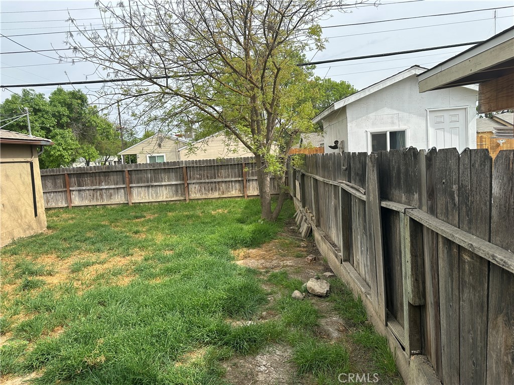 1888 Orchard Lane Merced, CA 95340 - Photo 28 of 28 a view of a backyard with a large tree and wooden fence