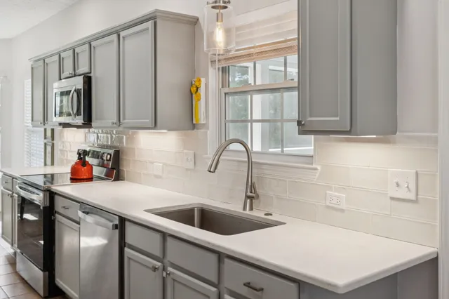 a kitchen with stainless steel appliances a sink a stove and a refrigerator with cabinets