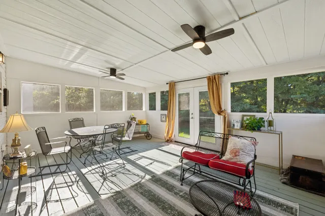 a living room with furniture a floor to ceiling window and a table
