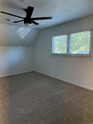 an empty room with a ceiling fan and a window