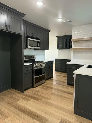 a kitchen with stainless steel appliances kitchen island granite countertop a refrigerator stove and microwave