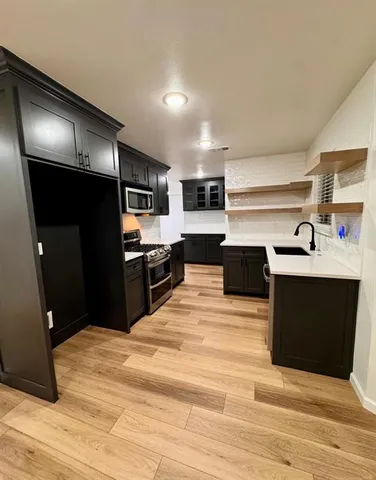 a kitchen with stainless steel appliances kitchen island sink refrigerator and stove