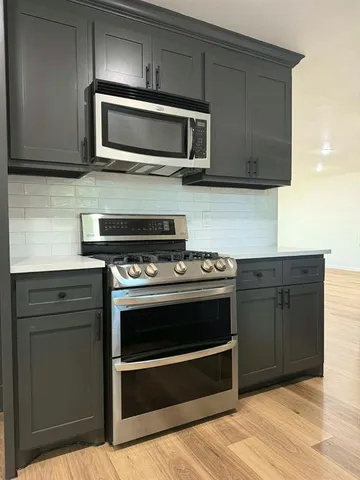 a kitchen with stainless steel appliances wooden cabinets and a stove top oven
