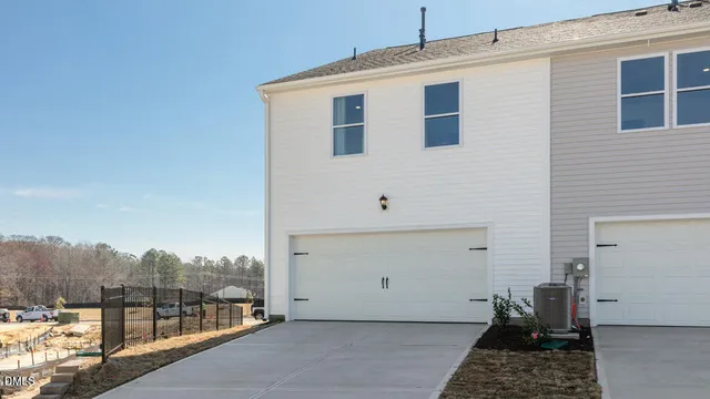 a view of a house with a floor to ceiling window next to a yard