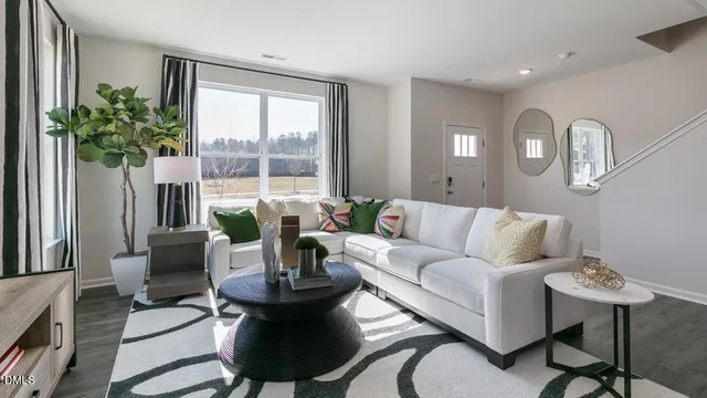a living room with furniture potted plant and a large window