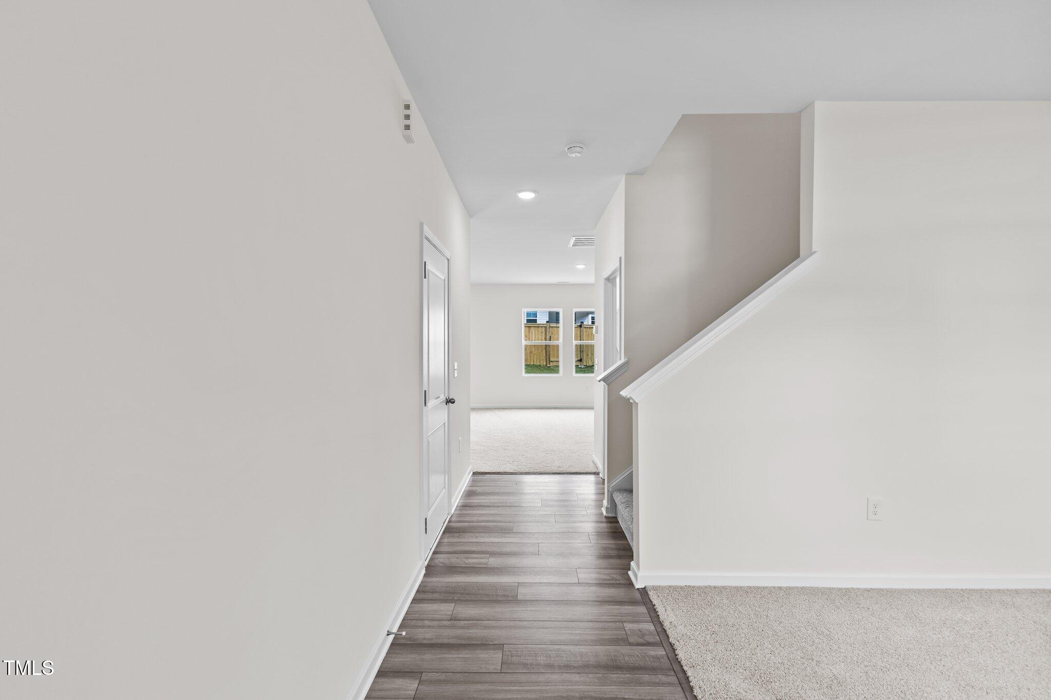 109 Gladstone Loop Clayton, NC 27520 - Photo 3 of 21 a view of a hallway with wooden floor and staircase