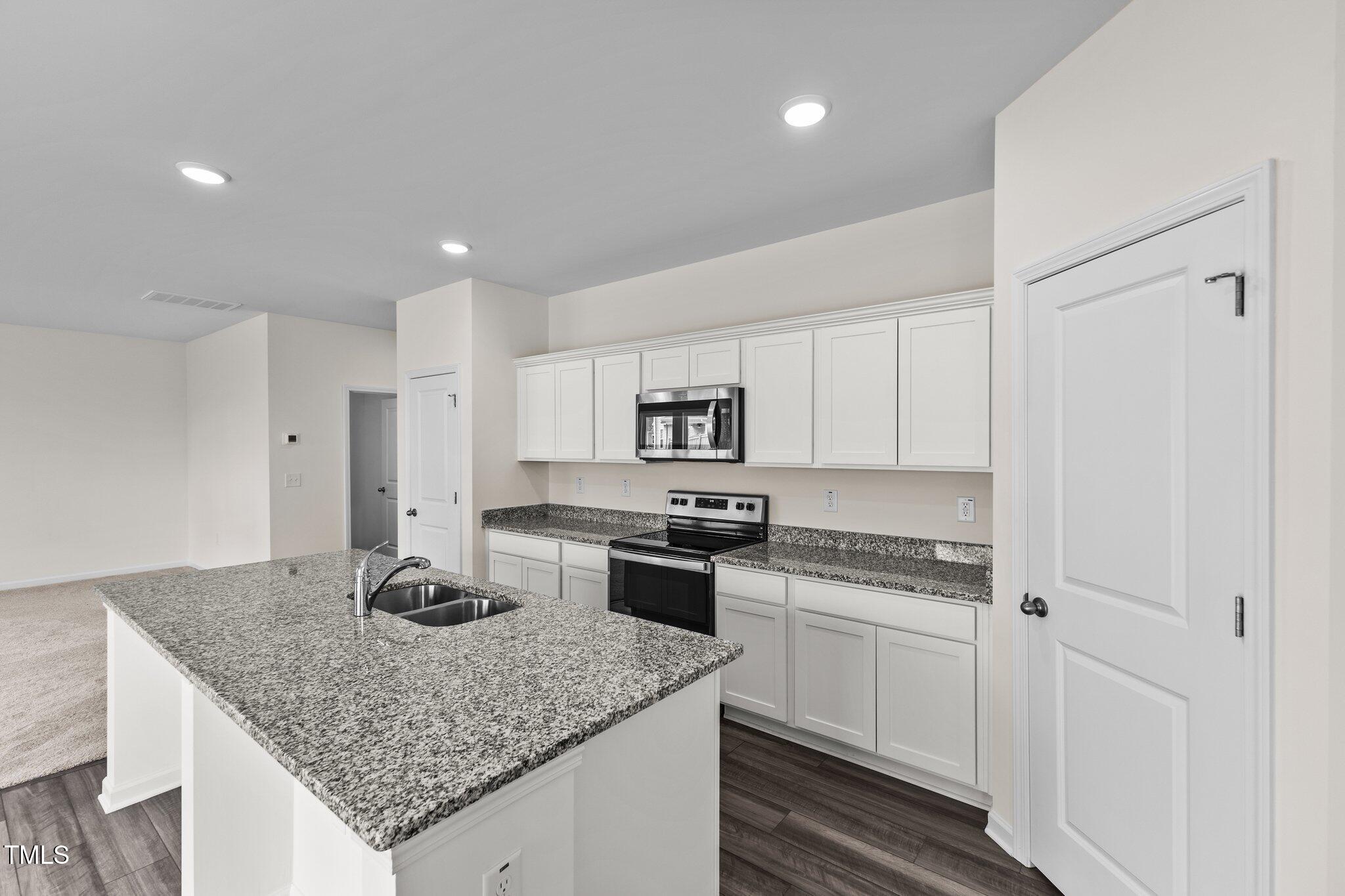109 Gladstone Loop Clayton, NC 27520 - Photo 7 of 21 a kitchen with stainless steel appliances granite countertop a sink stove and cabinets