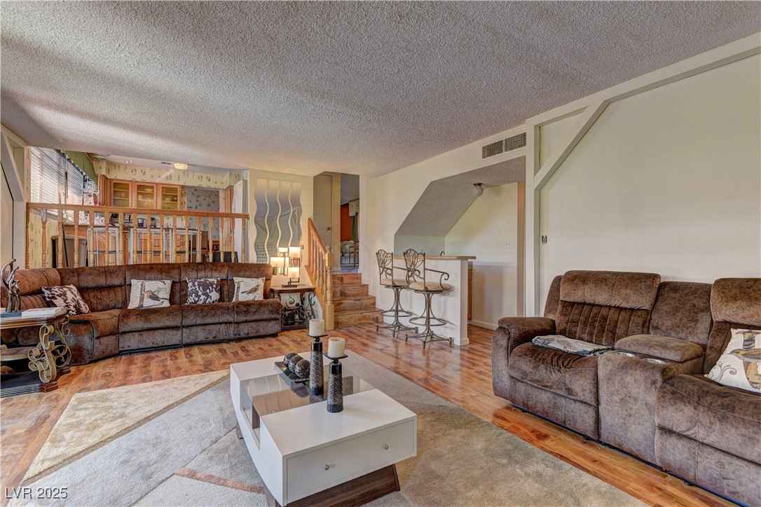 3751 El Camino Road Las Vegas, NV 89103 - Photo 15 of 27 Living area with wood finished floors, a textured ceiling, and stairway