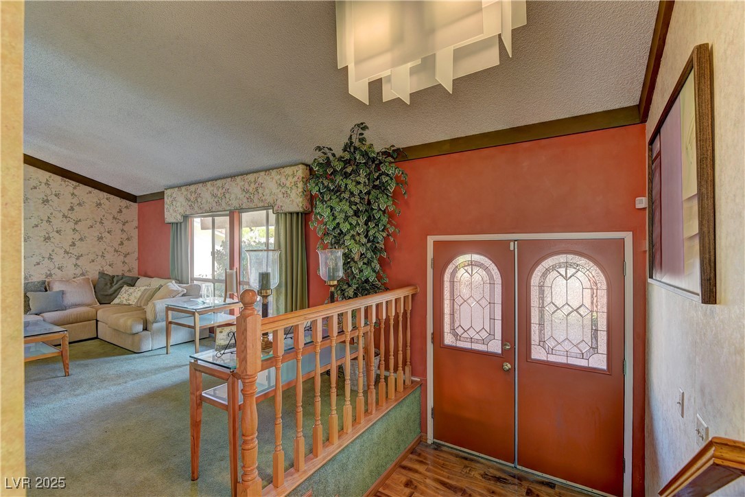 3751 El Camino Road Las Vegas, NV 89103 - Photo 6 of 27 Foyer entrance featuring a textured ceiling, french doors, wallpapered walls, wood finished floors, and crown molding