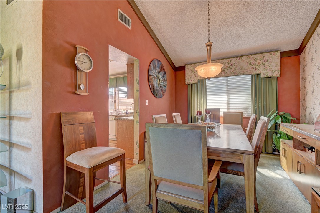 3751 El Camino Road Las Vegas, NV 89103 - Photo 9 of 27 Dining space with healthy amount of natural light, lofted ceiling, a textured ceiling, and light colored carpet
