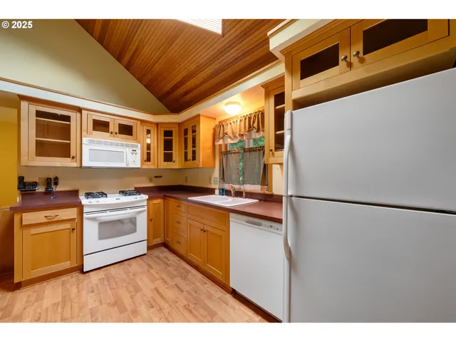 a kitchen with stainless steel appliances granite countertop a refrigerator a stove and a sink