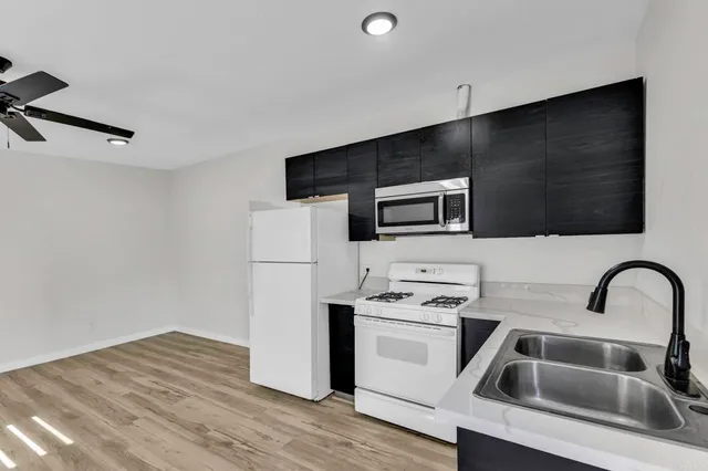 a kitchen with granite countertop a sink and stainless steel appliances