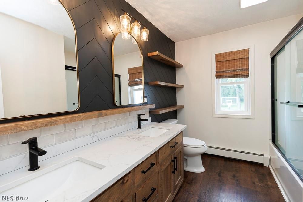 32618 Detroit Road Avon, OH 44011 - Photo 26 of 40 Dual vanity with integrated rectangular sinks, wood-finish cabinetry, and matte black fixtures