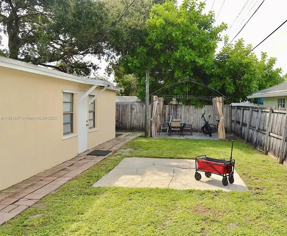 a view of backyard with table and chairs and wooden fence