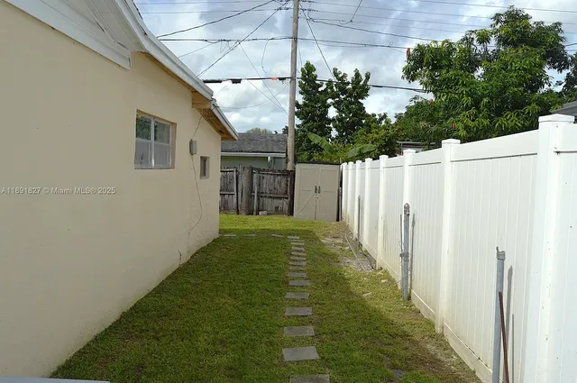 a view of a backyard with wooden fence