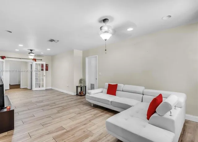 a living room with furniture and a wooden floor