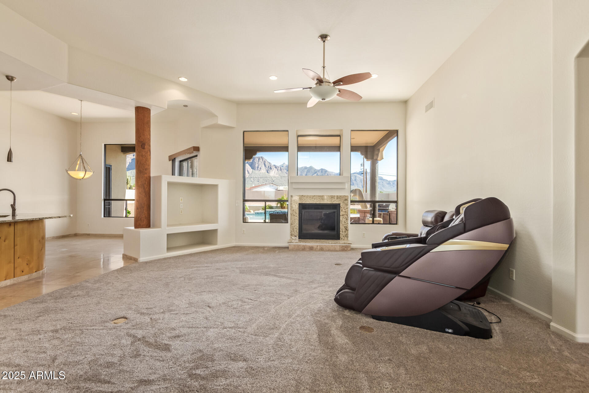 945 North Mountain View Road Apache Junction, AZ 85119 - Photo 12 of 53 a living room with furniture a fireplace and a floor to ceiling window