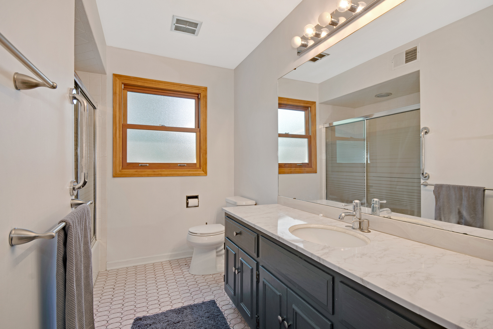 1214 Arthur Road Naperville, IL 60540 - Photo 13 of 21 a bathroom with a double vanity sink a toilet and a mirror