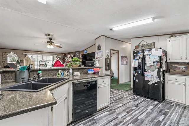a kitchen with granite countertop white cabinets and stainless steel appliances