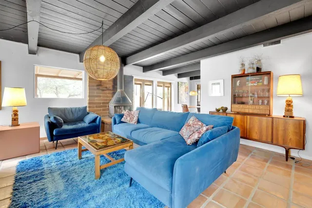 a living room with furniture fireplace and a large window