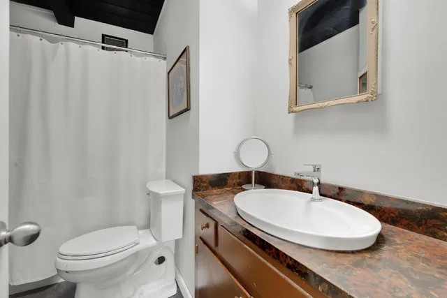 a bathroom with a sink toilet and a mirror