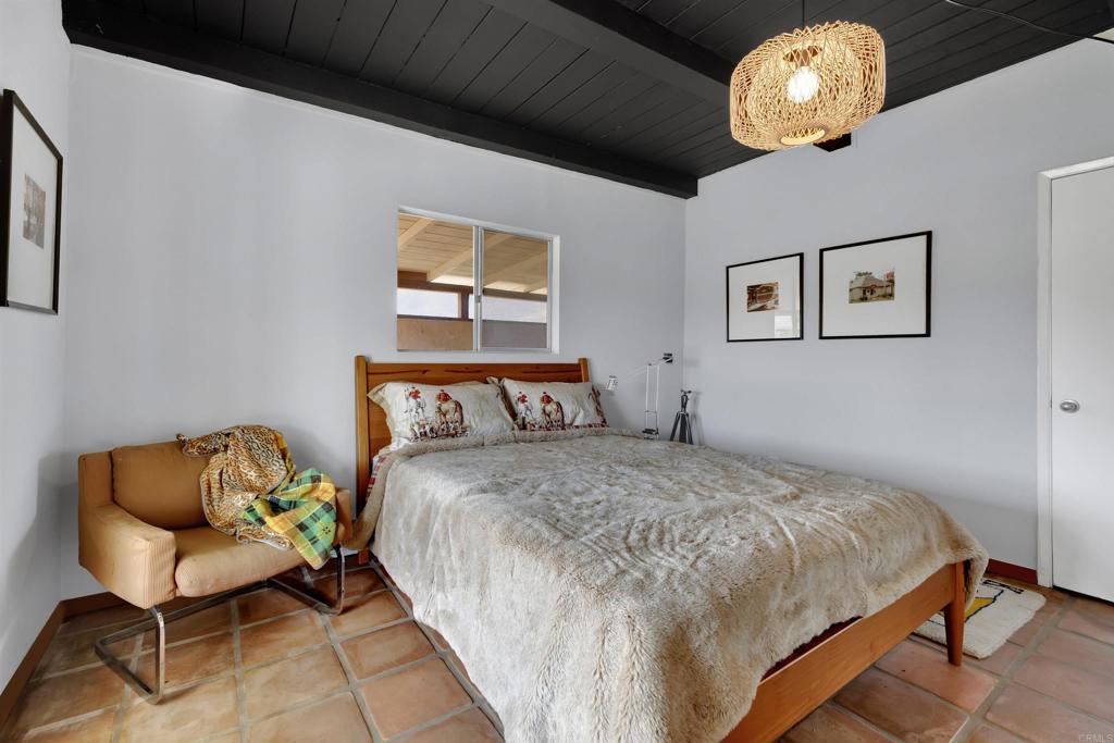 3211 Broken Arrow Road Borrego Springs, CA 92004 - Photo 19 of 46 a bedroom with a bed and a chandelier