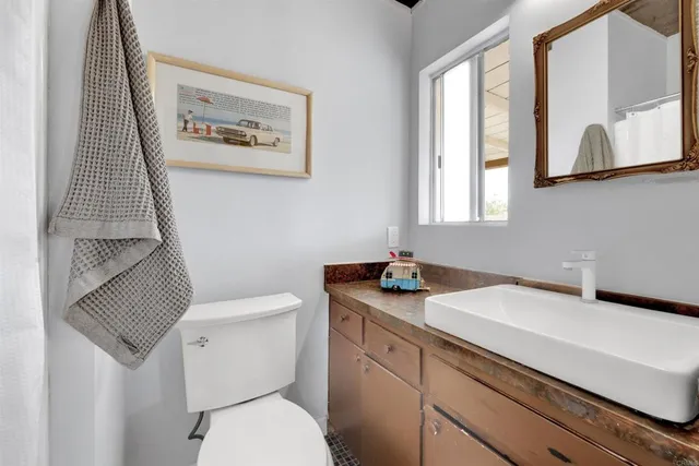 a bathroom with a toilet sink and mirror