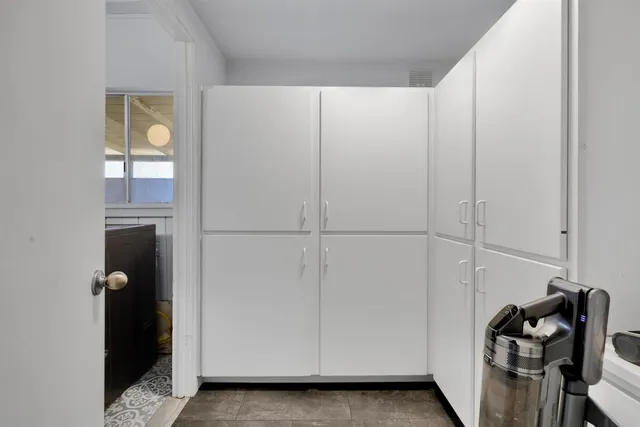 a view of an empty room with closet and a window