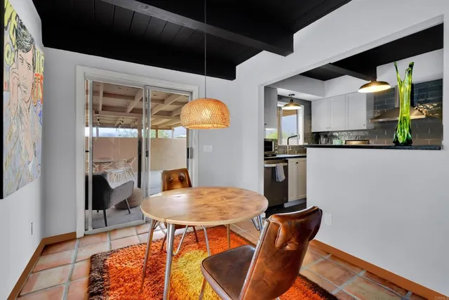 a kitchen with stainless steel appliances kitchen island granite countertop a table and chairs in it