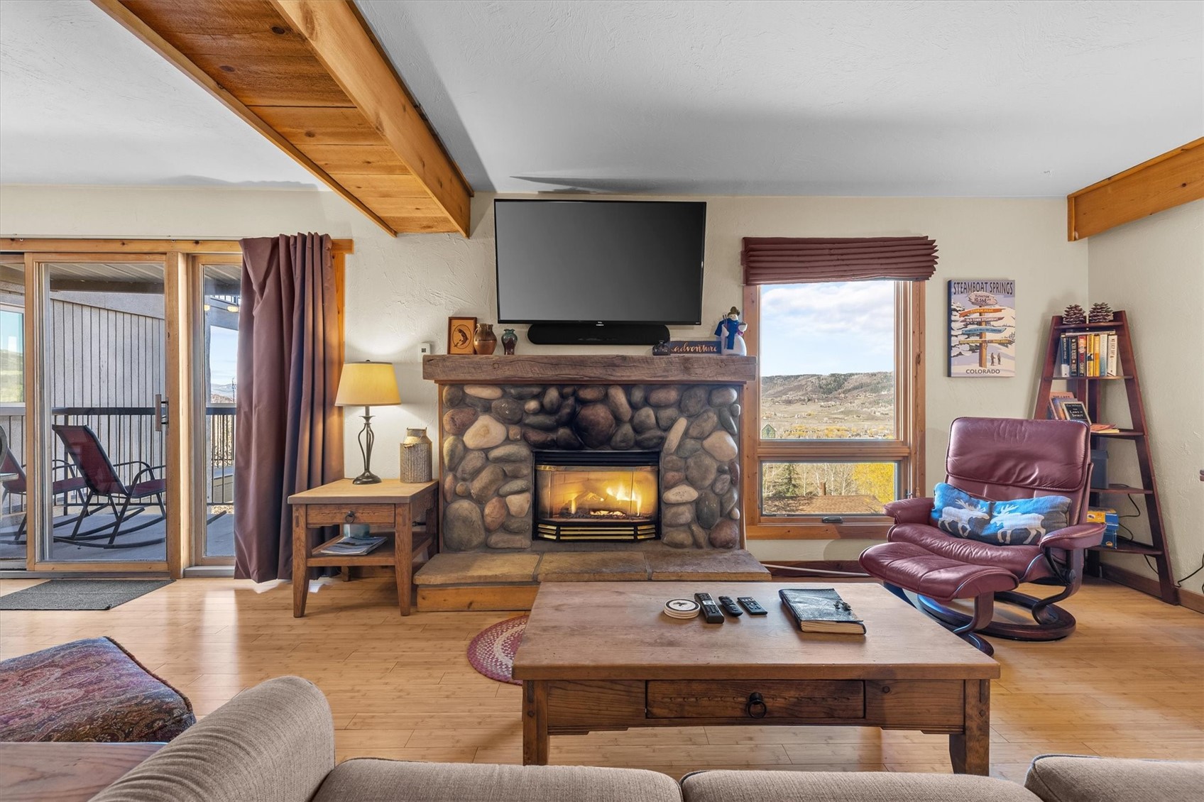 2602 Longthong Road, Unit 107 Steamboat Springs, CO 80487 - Photo 6 of 32 a living room with furniture a flat screen tv and a fireplace