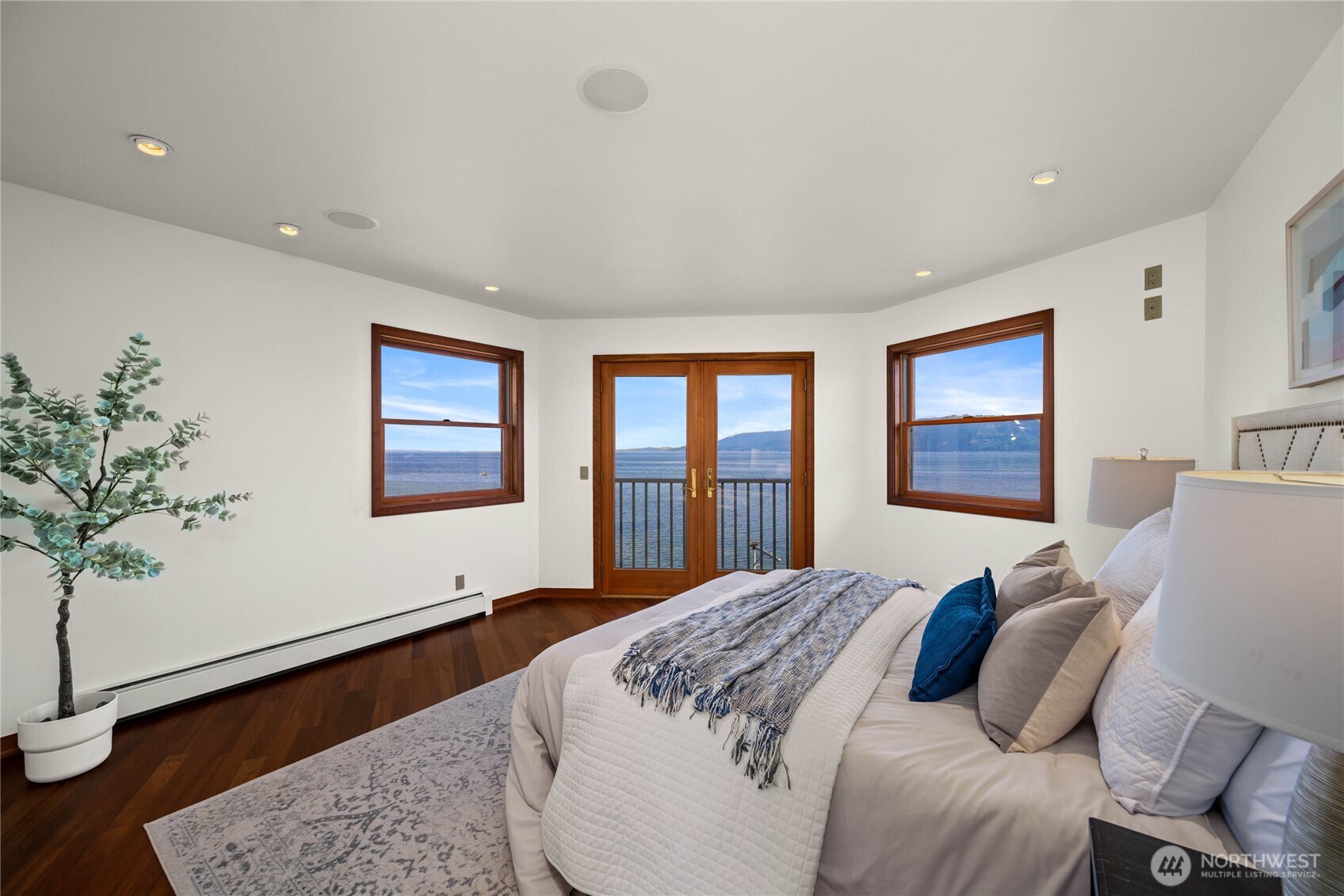 9551 Samish Island Road Bow, WA 98232 - Photo 24 of 40 a bedroom with a large bed and a potted plant