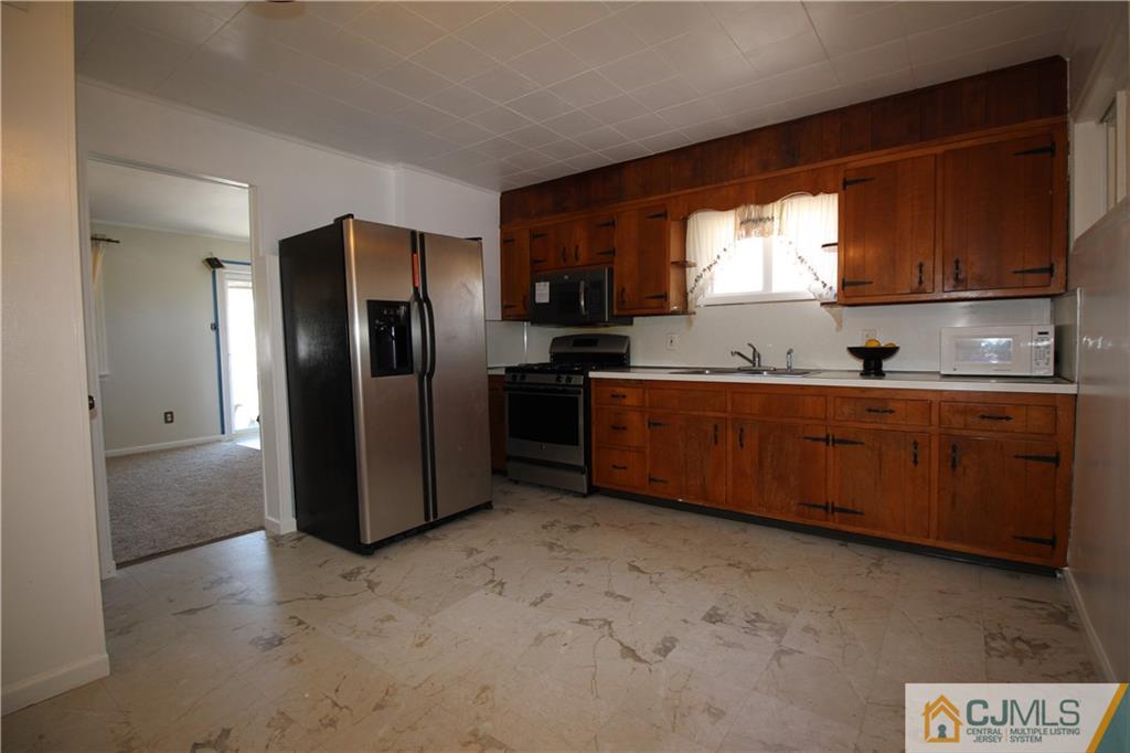 24 Gilmore Road Ewing, NJ 08628 - Photo 9 of 22 a kitchen with stainless steel appliances a sink and a refrigerator