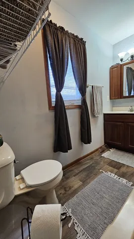 a bathroom with a toilet a sink and mirror