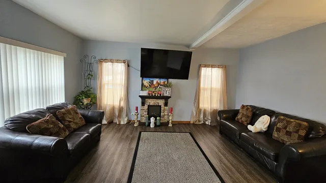 a living room with furniture fireplace and a large window