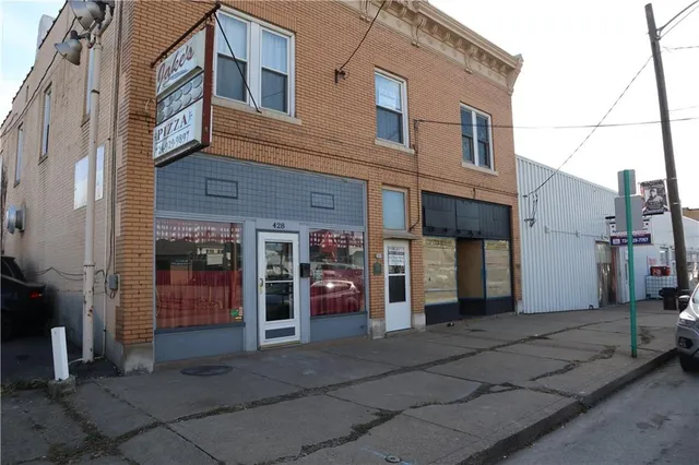 a view of a house with a barbeque and wooden door