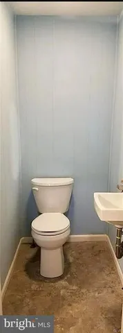 a white toilet sitting next to a white wall