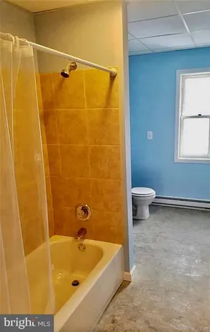 a bath tub sitting next to a blue sink and a toilet