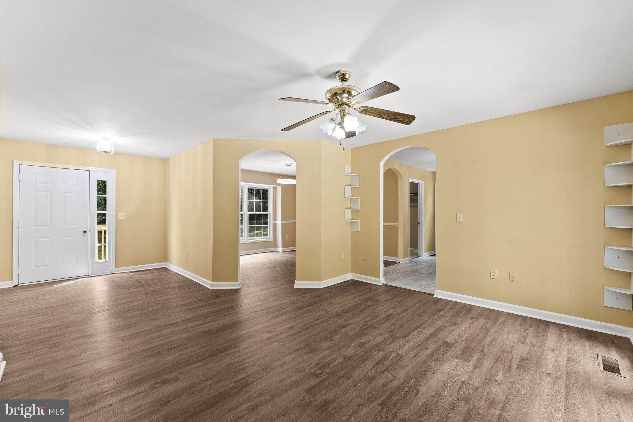 20065 Crooked Run Road Culpeper, VA 22701 - Photo 9 of 62 a view of an empty room with wooden floor and a ceiling fan