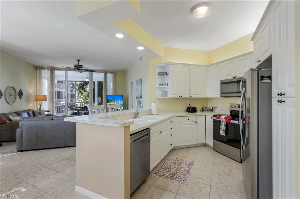 460 Launch Circle, Unit 301 Naples, FL 34108 - Photo 3 of 28 a kitchen with sink cabinets and refrigerator