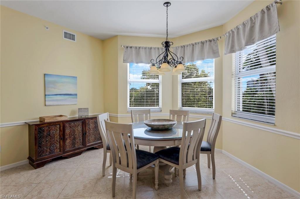 460 Launch Circle, Unit 301 Naples, FL 34108 - Photo 5 of 28 a dining room with furniture a chandelier and window