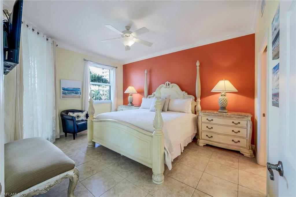 460 Launch Circle, Unit 301 Naples, FL 34108 - Photo 6 of 28 a bedroom with a bed and a chandelier