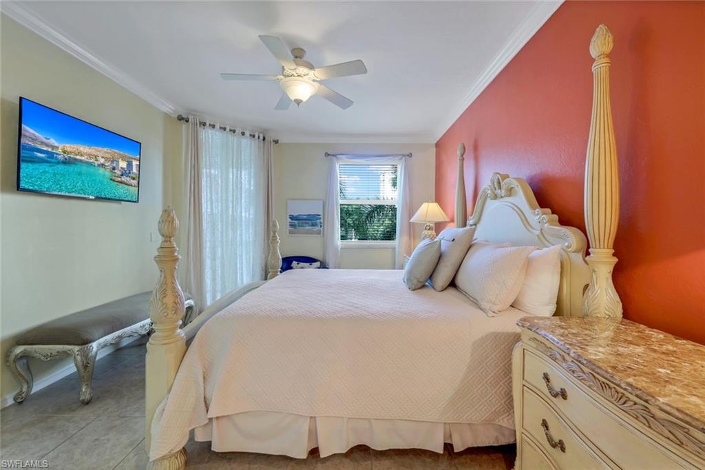 460 Launch Circle, Unit 301 Naples, FL 34108 - Photo 7 of 28 a bedroom with a bed and a chandelier
