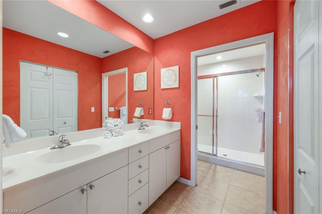 460 Launch Circle, Unit 301 Naples, FL 34108 - Photo 8 of 28 a spacious bathroom with a double vanity sink a large mirror and a shower