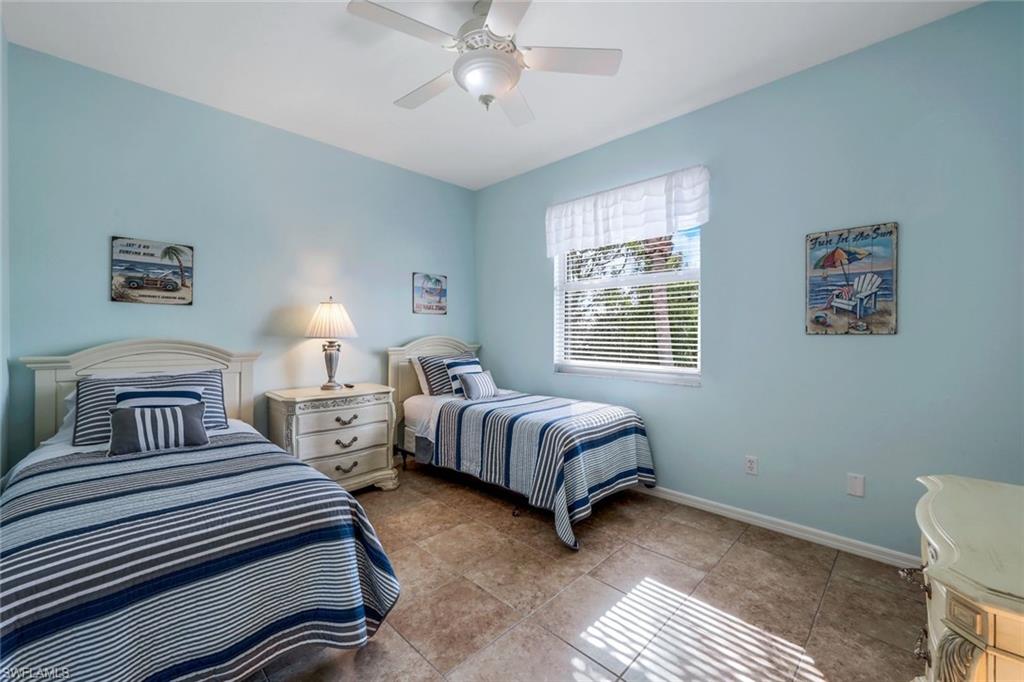 460 Launch Circle, Unit 301 Naples, FL 34108 - Photo 9 of 28 a bedroom with two beds and a chandelier