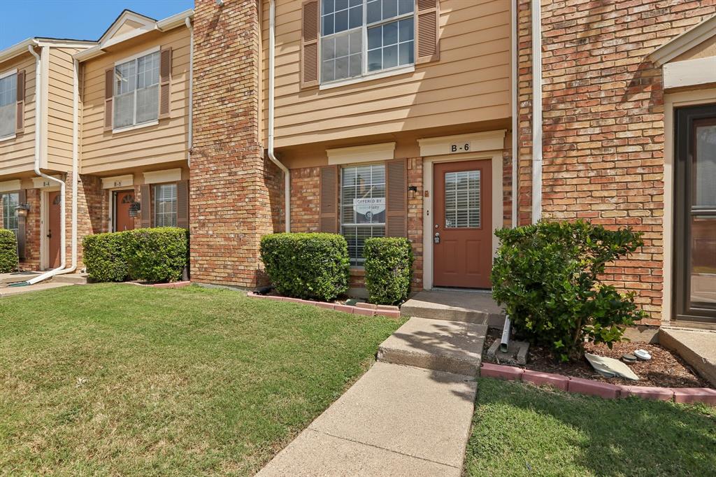 2400 Jupiter Road, Unit 6 Plano, TX 75074 - Photo 19 of 22 Exterior features include a tan siding facade with brick accents, brown shutters, and a front entry with a glass-paneled door