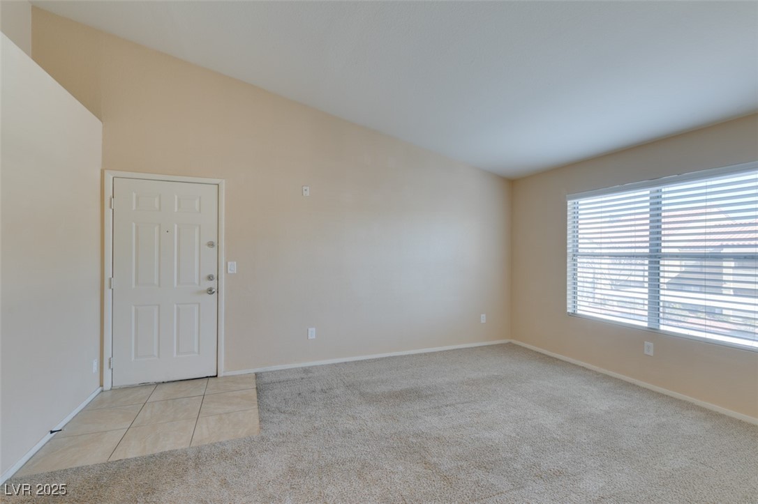 2300 East Silverado Ranch Boulevard, Unit 2190 Las Vegas, NV 89123 - Photo 14 of 41 Spare room with lofted ceiling, light carpet, and light tile patterned floors