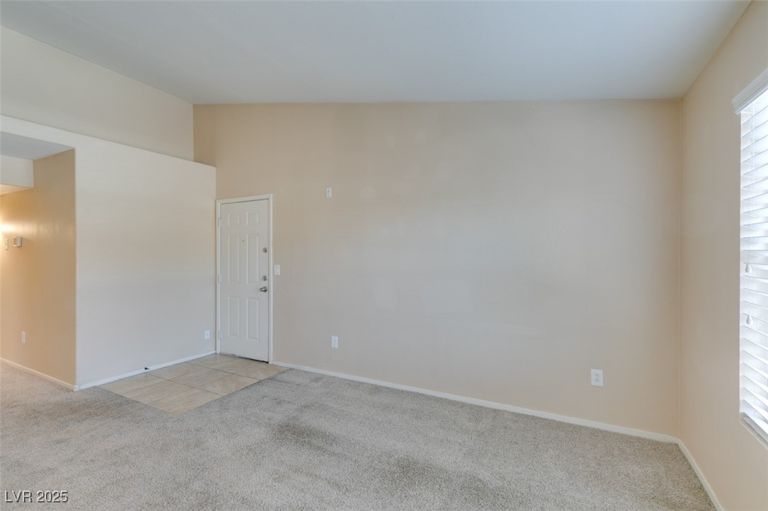 2300 East Silverado Ranch Boulevard, Unit 2190 Las Vegas, NV 89123 - Photo 19 of 41 Unfurnished room with light colored carpet, lofted ceiling, and light tile patterned flooring